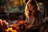 Fototapeta  - Attractive woman forming an autumn bouquet from seasonal flowers and decor during sunlight day