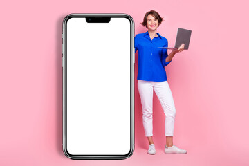 Poster - Full length photo cadre of young cheerful business woman wear formal clothes big touchscreen phone hold netbook isolated pink color background