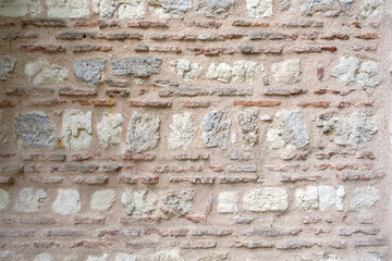 Close-up shot of a typical Byzantine wall in which red brick and stone are used together. weathered and worn historical wall