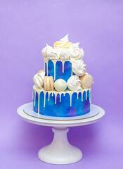 Wall Mural - Layered blue cake on cake stand on a purple background. A picture for a menu or a catalog of confectionery products.