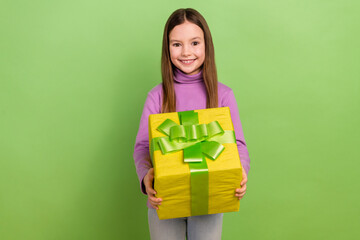 Sticker - Photo of schoolgirl children holding yellow wrapped package gift box present celebrate happy birthday isolated on green color background