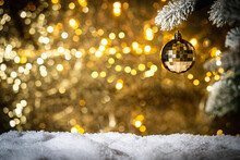Christmas Balls On Fir Branches With Gold Christmas Lights In Abstract Defocused Background