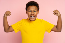 Strong Excited African Teenager Wearing T Shirt Showing Muscles, Biceps Isolated On Pink Background