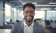 © Davis Brown - Portrait of a smiling Black man in business attire, set in an office environment. The photo captures a sense of diversity, happiness, and optimism.