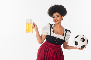 Wall Mural - african american oktoberfest waitress with soccer ball and mug of lager beer with foam on white