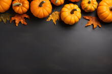 Yellow Dried Leaves And Small Orange Pumpkins On Black Background, Top View, Copy Space. Halloween, Thanksgiving Holiday Concept.