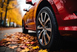 New red car wheel on autumn leaves