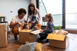 © BalanceFormCreative - Mixed race family moving into their new home. They're unpacking and having fun together.