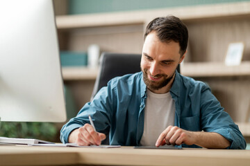 Aufkleber - Smiling Businessman Using Digital Tablet And Taking Notes To Notebook In Office