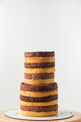 Wall Mural - Big stack of freshly baked biscuit cake layers. Black chocolate and white vanilla sponge cake layers on the white background. Mockup for cake recipe