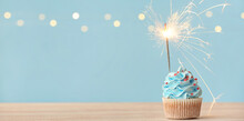 Tasty Cupcake With Sparkler On Light Blue Background With Space For Text