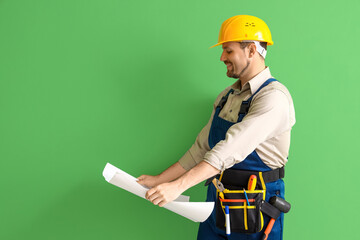 Canvas Print - Male builder with house plan on green background