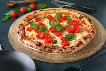 Wooden board with tasty pizza Margarita on black background