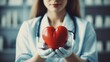 © visoot - Closeup female doctor holding red heart shape in hand.