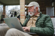 © Miljan Živković - Man senior caucasian male shopping online sit with laptop computer