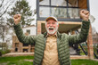 © Miljan Živković - One senior man stand outdoor in front of his house happy confident