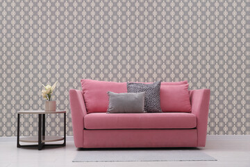 Wall Mural - Comfortable pink sofa and side table near wall. Minimalist living room interior