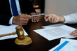 lawyer handing a pen to a client or business associate to sign a contract