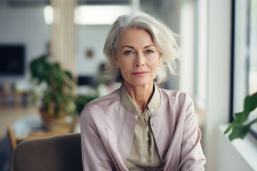 Smiling portrait of a happy senior woman working for a startup company in an office