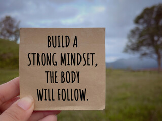 Wall Mural - Motivational and inspirational wording. Build A Strong Mindset, The Body Will Follow written on a notepad. With blurred styled background.