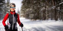 Mature Woman Cross Country Skiing On A Sunny Winter's Day. Concept Of Senior Exercise And Activities. Shallow Field Of View With Copy Space.