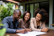 © Anoo - The African American family enters into a lease or purchase agreement for real estate. Business meeting when renting and buying a house, apartment. Mortgage. Affordable housing.