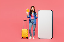 Traveler Woman Wear Casual Clothes Hold Bag Passport Ticket Big Huge Blank Screen Mobile Cell Phone Isolated On Plain Pink Background. Tourist Travel In Free Time Rest Getaway Air Flight Trip Concept