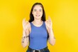 Beautiful woman wearing blue tank top showing both hands with fingers in OK sign. Approval or recommending concept