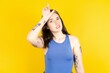 Beautiful woman wearing blue tank top making fun of people with fingers on forehead doing loser gesture mocking and insulting.