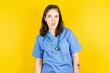 Portrait of dissatisfied Young caucasian doctor woman wearing blue medical uniform smirks face, purses lips and looks with annoyance at camera, discontent hearing something unpleasant