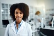 © Владимир Солдатов - Smiling african woman ophthalmologist in white coat in background of medical office.