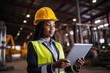 © Liaisan - Portrait of a young African American female engineer architect foreman. She is standing on the construction site and looking her tablet PC.