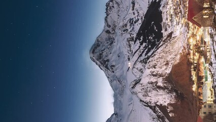 Wall Mural - Stepantsminda, Georgia. Hyperlapse Winter Night Starry Sky With Glowing Stars And Peak Of Mount Kazbek Covered With Snow. Beautiful Night Georgian Winter Landscape. Vertical Footage.