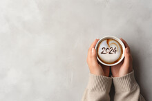 Happy New Year goal. Number 2024 on frothy surface of cappuccino coffee in cup. Resolutions Concept. Copy Space.