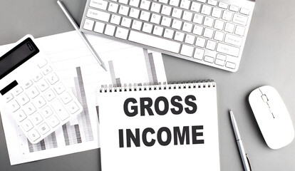 Poster - GROSS INCOME text written on notebook on grey background with chart and keyboard , business concept
