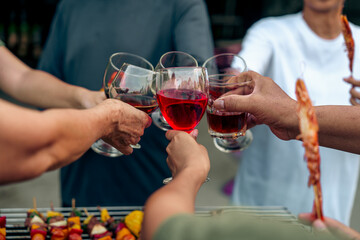 Home Garden BBQ Party, Wine Glasses Clink in Family Toast, enjoying harvest time together outside at front of house, grandfather and grandfather asian people, man and woman