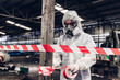 © kanpisut - Scientist wear Chemical protection suit check danger chemical, working at dangerous zone in Red and White Lines of barrier tape. Red and white Hazardous restricted area factory safety worker industry