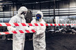 © kanpisut - Scientist wear Chemical protection suit check danger chemical, working at dangerous zone in Red and White Lines of barrier tape. Red and white Hazardous restricted area factory safety worker industry