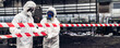 © kanpisut - Scientist wear Chemical protection suit check danger chemical, working at dangerous zone in Red and White Lines of barrier tape. Red and white Hazardous restricted area factory safety worker industry
