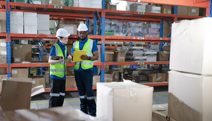 Distribution warehouse worker using tablet and checklist examining inventory on shelf. Merchandise supervisor, logistic engineer working at storage room in storehouse for goods retail order management