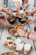 © Leslie Rodriguez - hands reaching over a table to pick up food