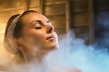 Young woman relaxing and sweating in hot sauna - Relax in hot bathhouse with steam