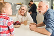 © Yakobchuk Olena - Cute grandmother and grandfather talking with little girl during the breakfast
