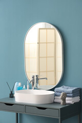 Poster - White sink with bath accessories on table near color wall