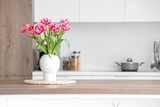 Fototapeta Tulipany - Vase with tulips on table in light kitchen