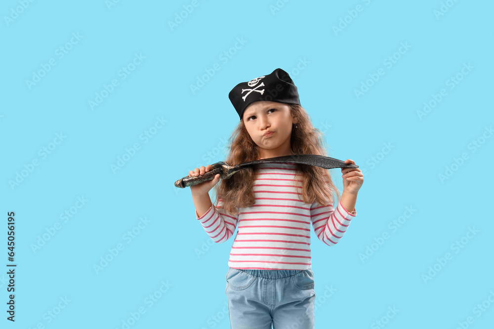 Cute little girl dressed as pirate with sword on blue background
