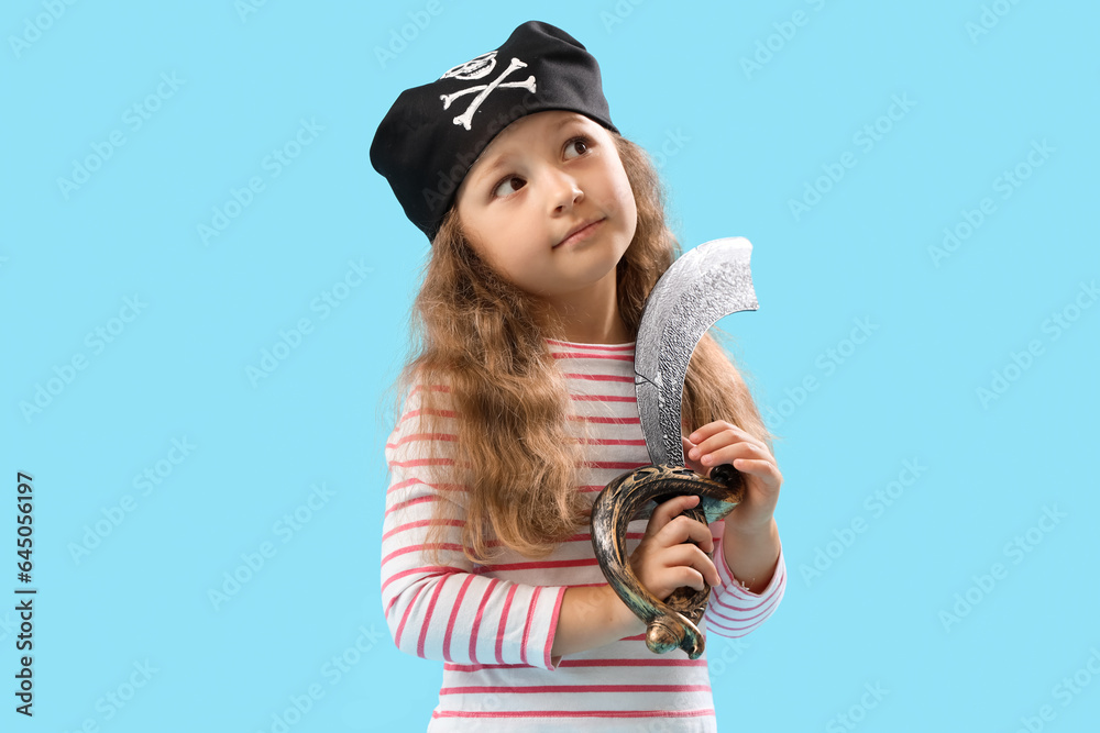 Cute little girl dressed as pirate with sword on blue background