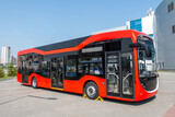 Fototapeta Big Ben - Red modern city bus at the bus station on a clear day