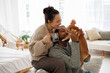 © Dmytro Hai - Cheerful young interracial couple with coffee playing with chihuahua dog at home