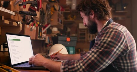 Web research, man and writing computer data with planning, notes and project information. Workshop, male person and work analysis on website and internet for DIY craftsman search and carpenter job